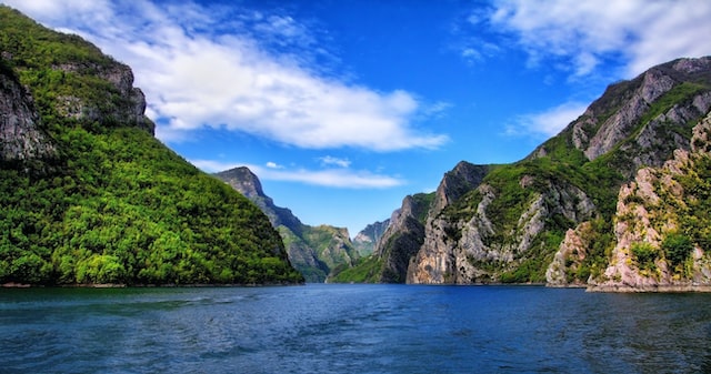 lake between  green mountains and a blue sky