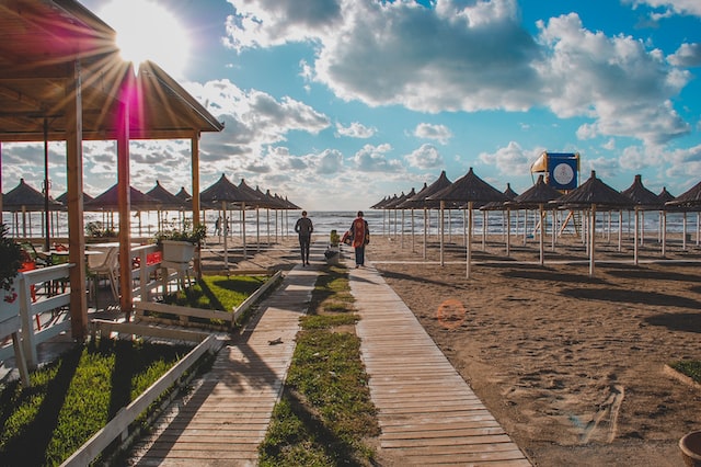  a family walking on the beach beetwen deckchairs